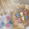 This image showcases beautifully packaged baby shower favors in the shape of small baby feet, made of wax. The favors come in pastel colors, including pink, blue, and white, and are individually wrapped in clear plastic with a 