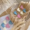 This image showcases beautifully packaged baby shower favors in the shape of small baby feet, made of wax. The favors come in pastel colors, including pink, blue, and white, and are individually wrapped in clear plastic with a 