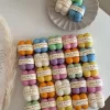 A collection of colorful candles labeled with personalized tags, alongside mini baby bubble candles for special events.