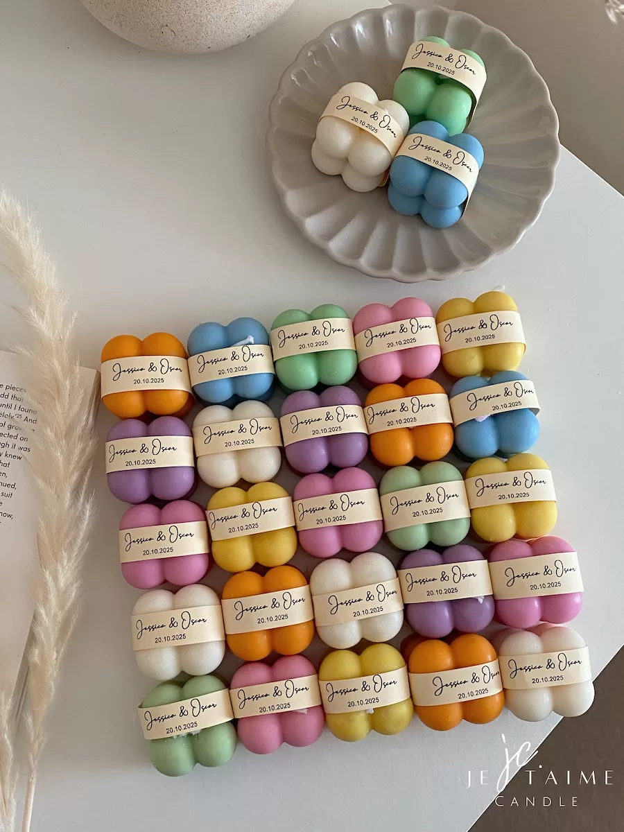 A collection of colorful candles labeled with personalized tags, alongside mini baby bubble candles for special events.
