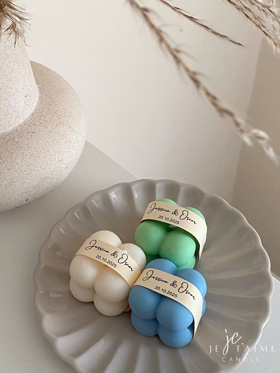 A collection of colorful candles labeled with personalized tags, alongside mini baby bubble candles for special events.