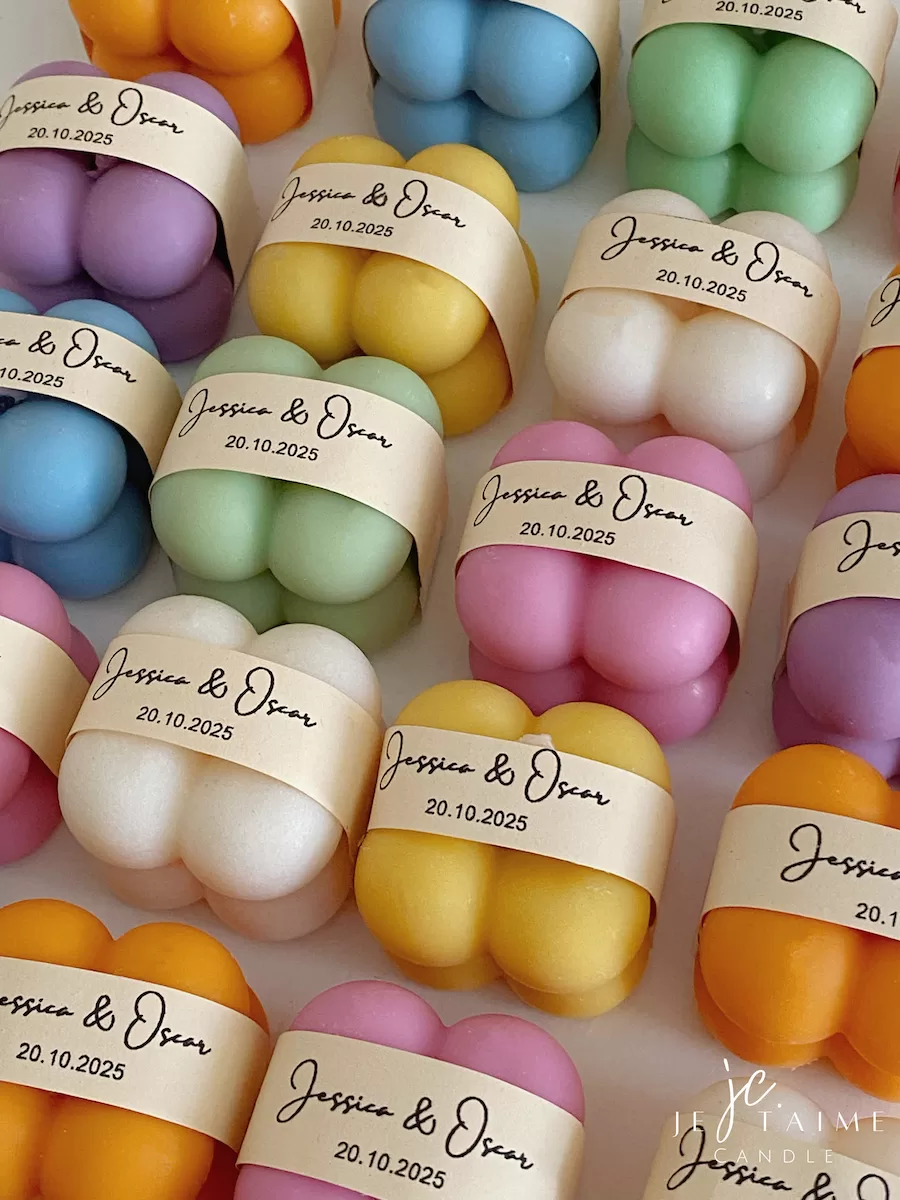 A collection of colorful candles labeled with personalized tags, alongside mini baby bubble candles for special events.