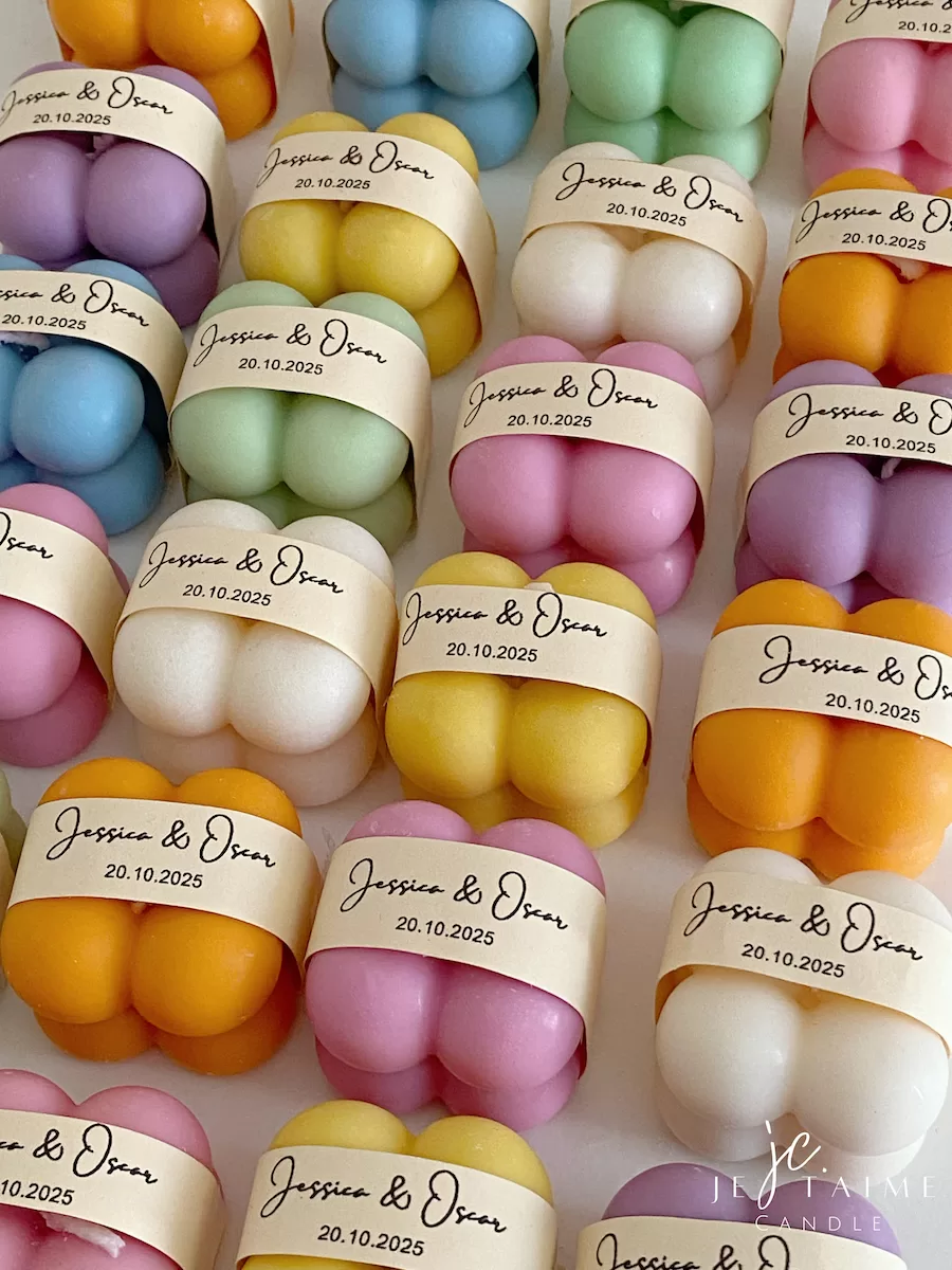 A collection of colorful candles labeled with personalized tags, alongside mini baby bubble candles for special events.