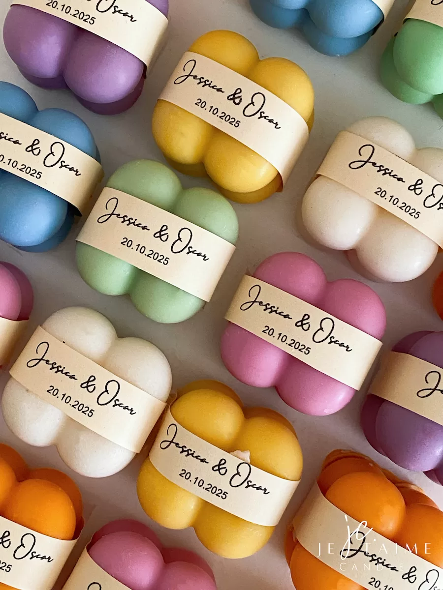 A collection of colorful candles labeled with personalized tags, alongside mini baby bubble candles for special events.