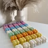 A collection of colorful candles labeled with personalized tags, alongside mini baby bubble candles for special events.