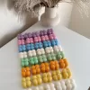 A collection of colorful candles labeled with personalized tags, alongside mini baby bubble candles for special events.