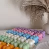 A collection of colorful candles labeled with personalized tags, alongside mini baby bubble candles for special events.