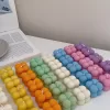 A collection of colorful candles labeled with personalized tags, alongside mini baby bubble candles for special events.