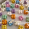 A collection of colorful candles labeled with personalized tags, alongside mini baby bubble candles for special events.