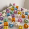 A collection of colorful candles labeled with personalized tags, alongside mini baby bubble candles for special events.