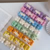 A collection of colorful candles labeled with personalized tags, alongside mini baby bubble candles for special events.