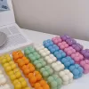 A collection of colorful candles labeled with personalized tags, alongside mini baby bubble candles for special events.