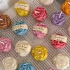 A book with an assortment of colorful candles on it, highlighting a Mini Peony Bud Candle, perfect for gifting at special events.