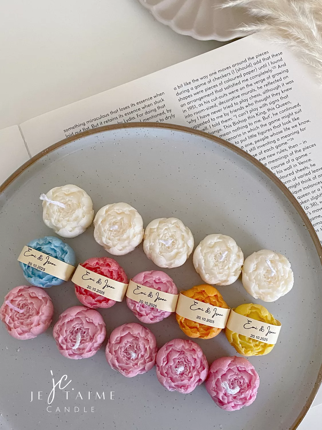 A book with an assortment of colorful candles on it, highlighting a Mini Peony Bud Candle, perfect for gifting at special events.