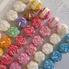 A book with an assortment of colorful candles on it, highlighting a Mini Peony Bud Candle, perfect for gifting at special events.