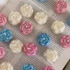 A book with an assortment of colorful candles on it, highlighting a Mini Peony Bud Candle, perfect for gifting at special events.