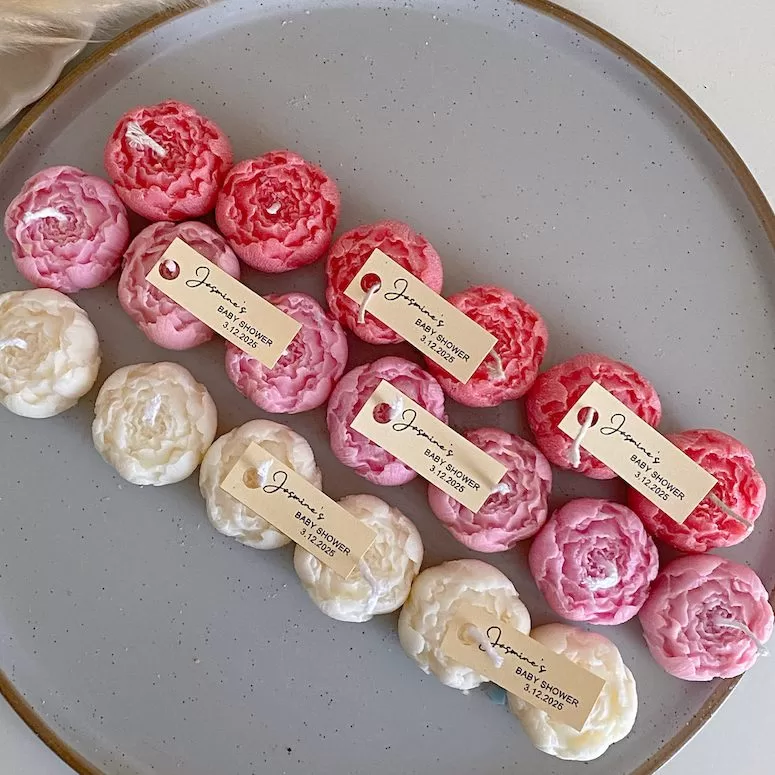 A book with an assortment of colorful candles on it, highlighting a Mini Peony Bud Candle, perfect for gifting at special events.