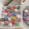 A book with an assortment of colorful candles on it, highlighting a Mini Peony Bud Candle, perfect for gifting at special events.