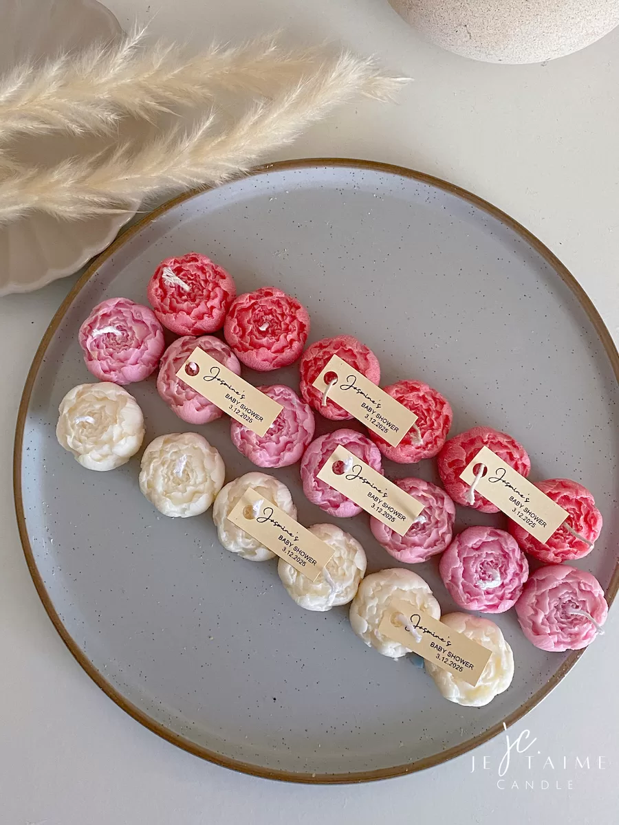 A book with an assortment of colorful candles on it, highlighting a Mini Peony Bud Candle, perfect for gifting at special events.