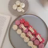 A book with an assortment of colorful candles on it, highlighting a Mini Peony Bud Candle, perfect for gifting at special events.