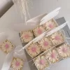 Set of handmade daisy-shaped candles with white petals and pink centers, displayed on a fabric surface – perfect for wedding favors, bridal shower gifts, or spring party decorations.