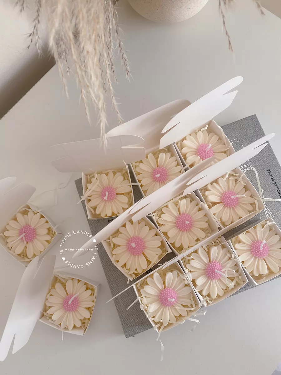 Set of handmade daisy-shaped candles with white petals and pink centers, displayed on a fabric surface – perfect for wedding favors, bridal shower gifts, or spring party decorations.