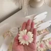 Set of handmade daisy-shaped candles with white petals and pink centers, displayed on a fabric surface – perfect for wedding favors, bridal shower gifts, or spring party decorations.
