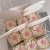 Set of handmade daisy-shaped candles with white petals and pink centers, displayed on a fabric surface – perfect for wedding favors, bridal shower gifts, or spring party decorations.
