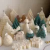 A table adorned with a variety of colorful Christmas decorations, including Christmas Tree Candles, Pinecone Shaped Candle, Angel Candle, Snowflake Christmas Candle, Town House Candle, Gingerbread Men Candle, Deer Candle.