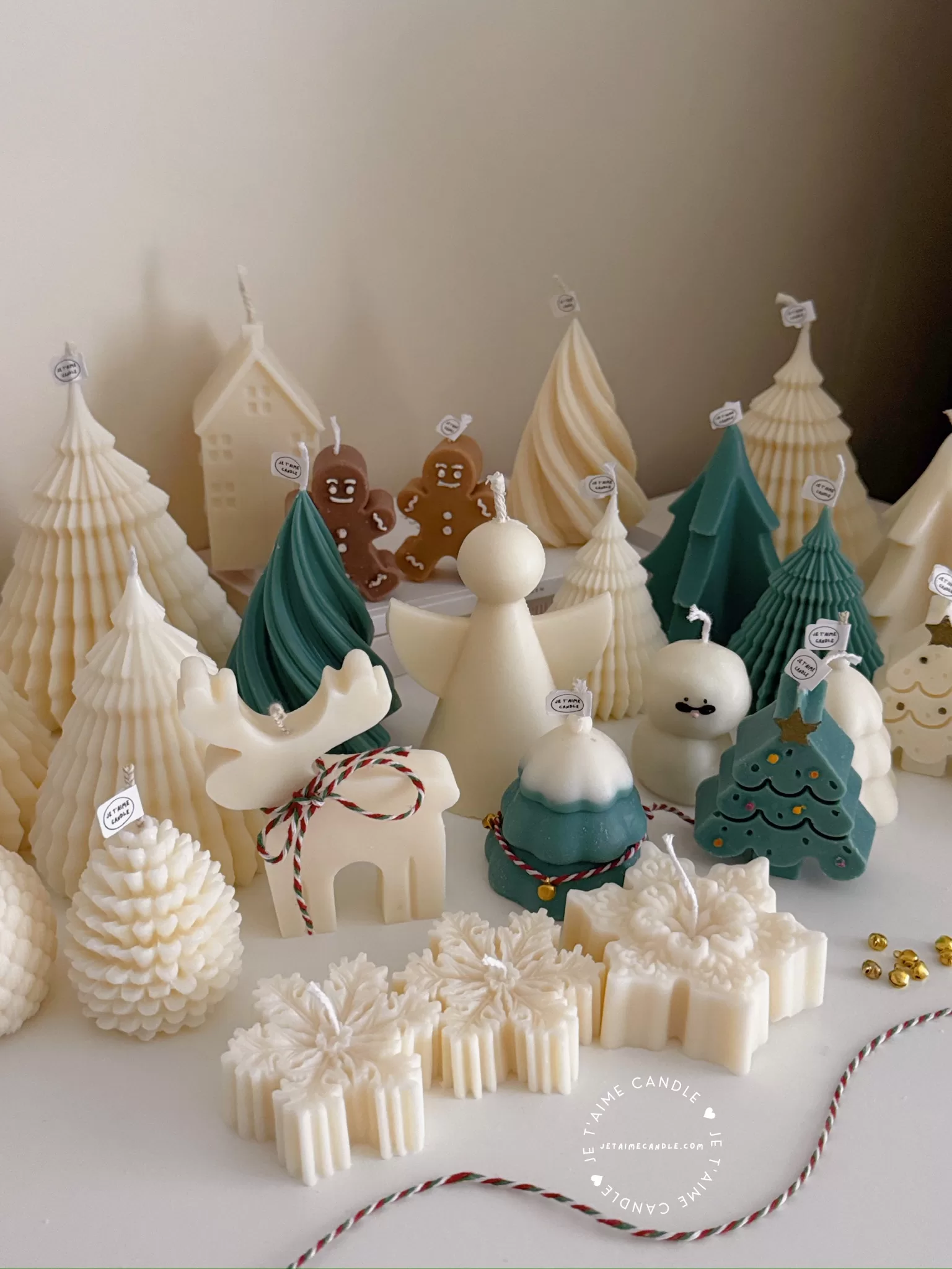 A table adorned with a variety of colorful Christmas decorations, including Christmas Tree Candles, Pinecone Shaped Candle, Angel Candle, Snowflake Christmas Candle, Town House Candle, Gingerbread Men Candle, Deer Candle.