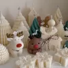 A table adorned with a variety of colorful Christmas decorations, including Christmas Tree Candles, Pinecone Shaped Candle, Angel Candle, Snowflake Christmas Candle, Town House Candle, Gingerbread Men Candle, Deer Candle.