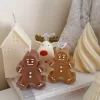 Christmas candles surrounded by a gingerbread man and a reindeer, creating a festive holiday atmosphere.