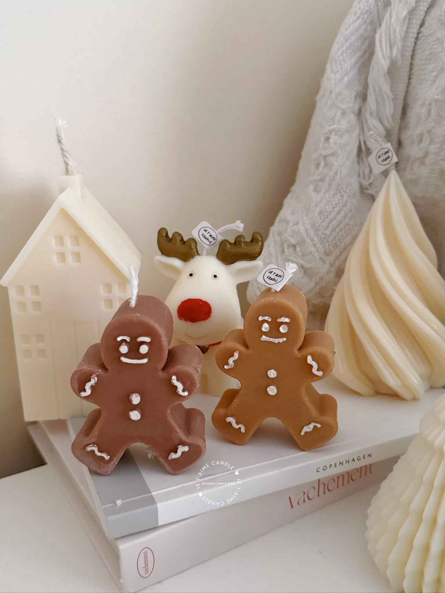 Christmas candles surrounded by a gingerbread man and a reindeer, creating a festive holiday atmosphere.
