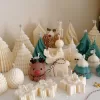 A table adorned with a variety of colorful Christmas decorations, including Christmas Tree Candles, Pinecone Shaped Candle, Angel Candle, Snowflake Christmas Candle, Town House Candle, Gingerbread Men Candle, Deer Candle.