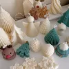 A table adorned with a variety of colorful Christmas decorations, including Christmas Tree Candles, Pinecone Shaped Candle, Angel Candle, Snowflake Christmas Candle, Town House Candle, Gingerbread Men Candle, Deer Candle.