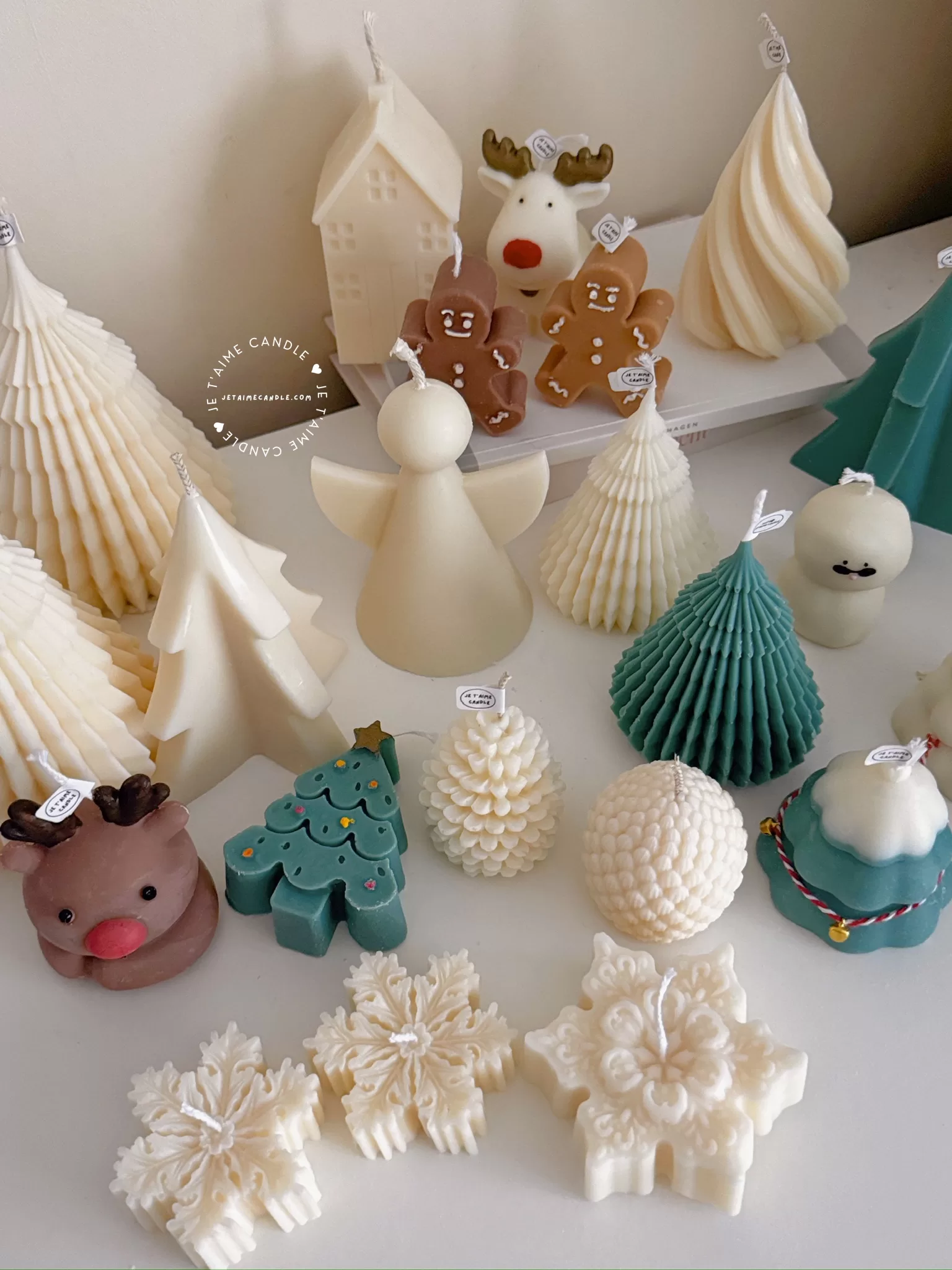 A table adorned with a variety of colorful Christmas decorations, including Christmas Tree Candles, Pinecone Shaped Candle, Angel Candle, Snowflake Christmas Candle, Town House Candle, Gingerbread Men Candle, Deer Candle.
