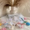 Colorful rose candles in pink, blue, yellow, and white, wrapped in white organza bags with personalized 'Thank You' tags for Amy's baby shower on 12/01/2024, displayed with pampas grass decor in the background