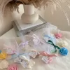 Colorful rose candles in pink, blue, yellow, and white, wrapped in white organza bags with personalized 'Thank You' tags for Amy's baby shower on 12/01/2024, displayed with pampas grass decor in the background