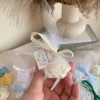 Colorful rose candles in pink, blue, yellow, and white, wrapped in white organza bags with personalized 'Thank You' tags for Amy's baby shower on 12/01/2024, displayed with pampas grass decor in the background