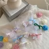 Colorful rose candles in pink, blue, yellow, and white, wrapped in white organza bags with personalized 'Thank You' tags for Amy's baby shower on 12/01/2024, displayed with pampas grass decor in the background