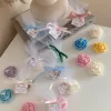 Colorful rose candles in pink, blue, yellow, and white, wrapped in white organza bags with personalized 'Thank You' tags for Amy's baby shower on 12/01/2024, displayed with pampas grass decor in the background