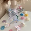 Colorful rose candles in pink, blue, yellow, and white, wrapped in white organza bags with personalized 'Thank You' tags for Amy's baby shower on 12/01/2024, displayed with pampas grass decor in the background