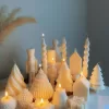 Set of white decorative candles shaped like Christmas trees, nutcrackers, angel, pinecones, and snowflakes, elegant holiday decor and gift.