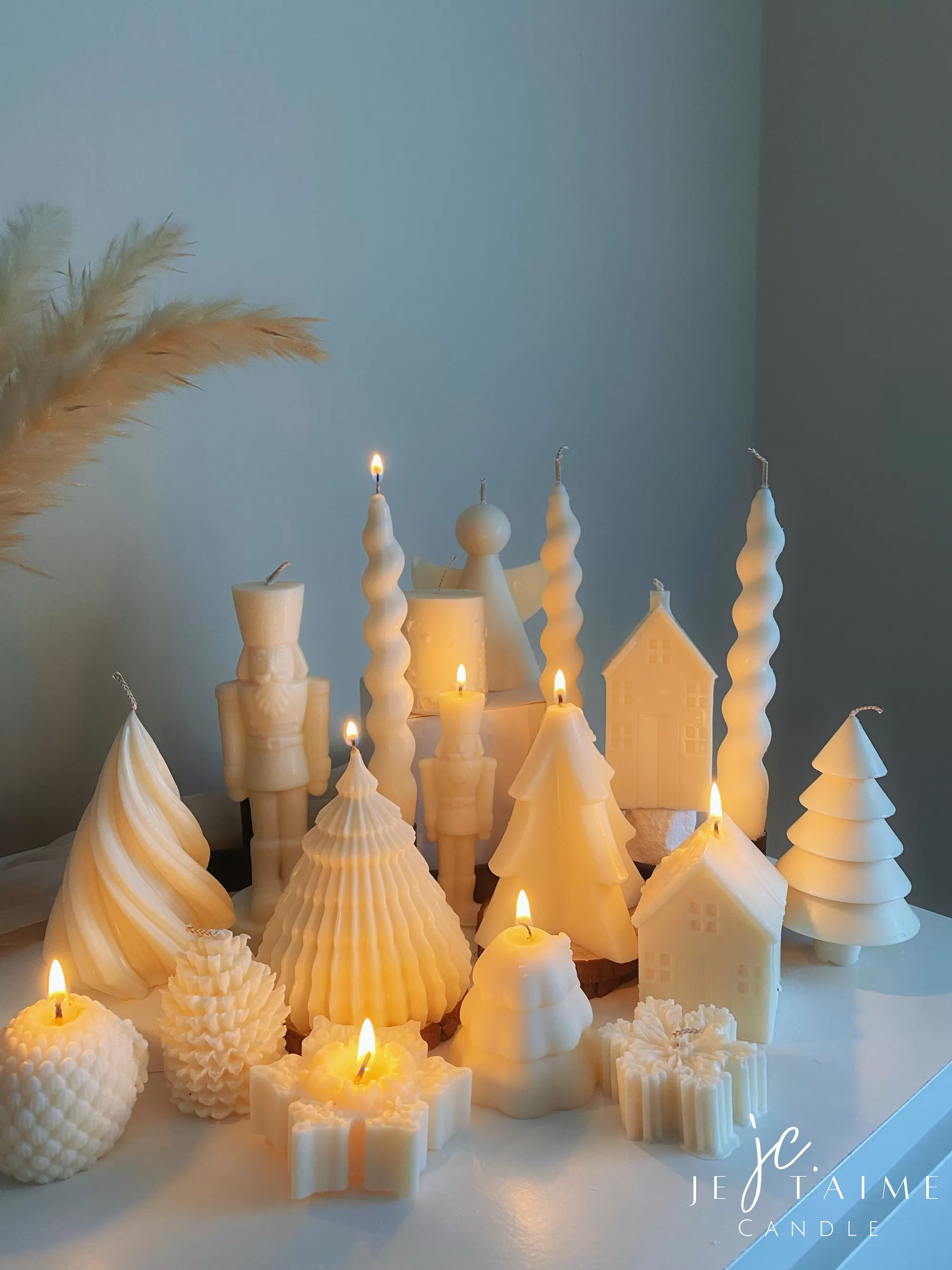 Set of white decorative candles shaped like Christmas trees, nutcrackers, angel, pinecones, and snowflakes, elegant holiday decor and gift.