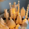 Set of white decorative candles shaped like Christmas trees, nutcrackers, angel, pinecones, and snowflakes, elegant holiday decor and gift.