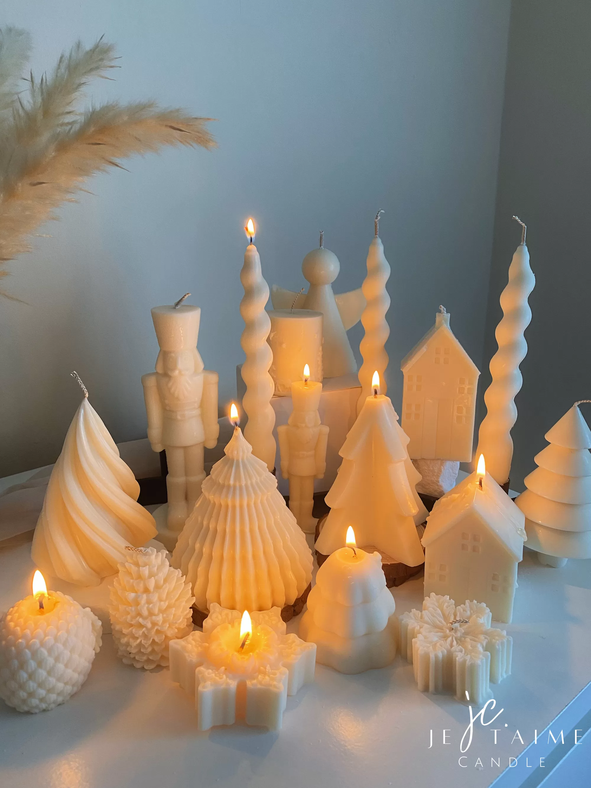 Set of white decorative candles shaped like Christmas trees, nutcrackers, angel, pinecones, and snowflakes, elegant holiday decor and gift.