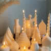 Set of white decorative candles shaped like Christmas trees, nutcrackers, angel, pinecones, and snowflakes, elegant holiday decor and gift.