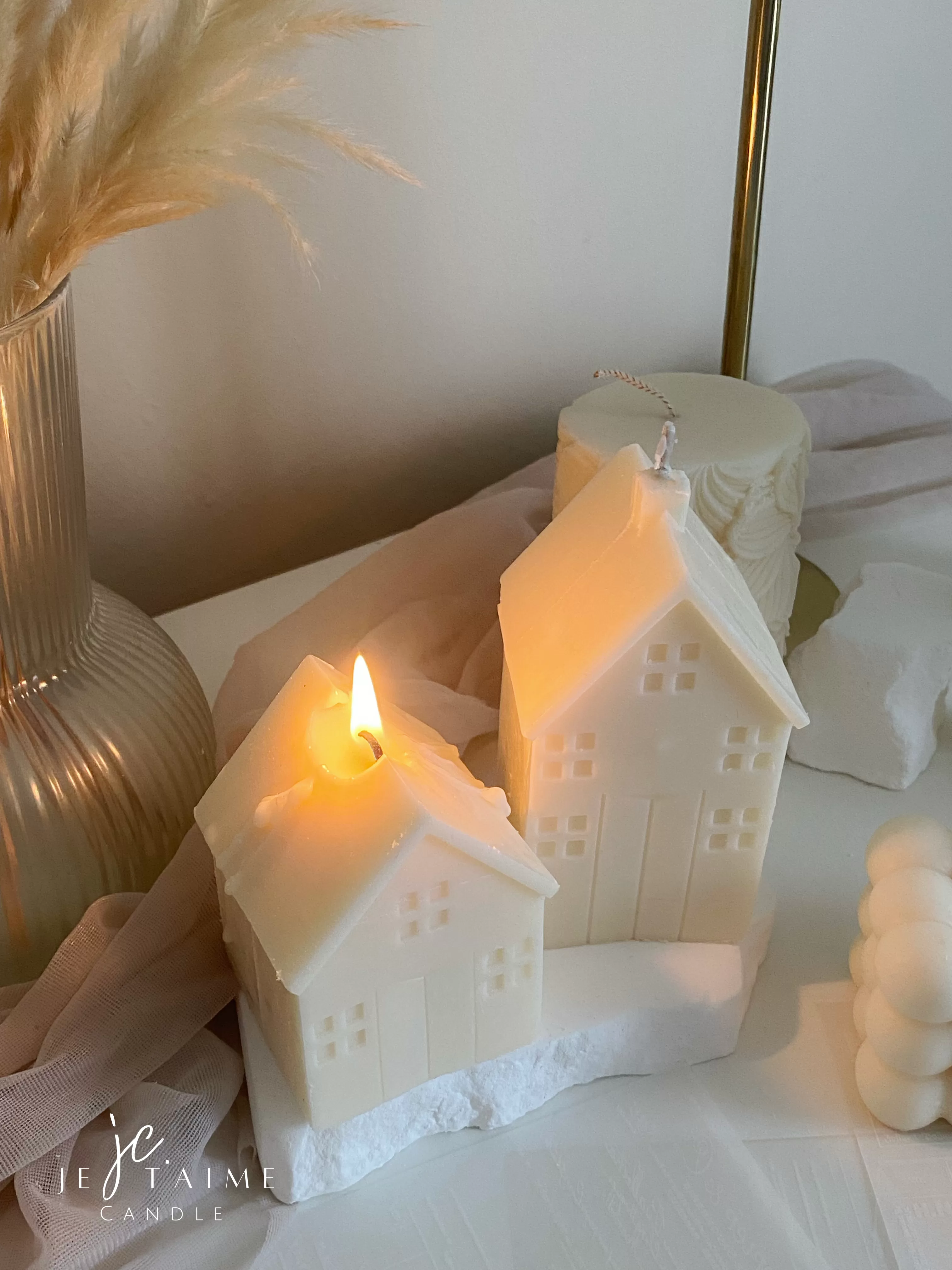 Handmade soy wax house-shaped candles in creamy white, styled with bubble cube candle and decorative accents, perfect for minimalist home décor, cozy table styling, wedding centerpieces, or unique handmade gift ideas.