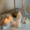 Assorted handmade Christmas candles in festive shapes including Pinecone, snowflakes, taper candle, displayed together in holiday-themed colors.