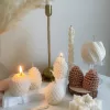 Assorted handmade Christmas candles in festive shapes including Pinecone, snowflakes, taper candle, displayed together in holiday-themed colors.
